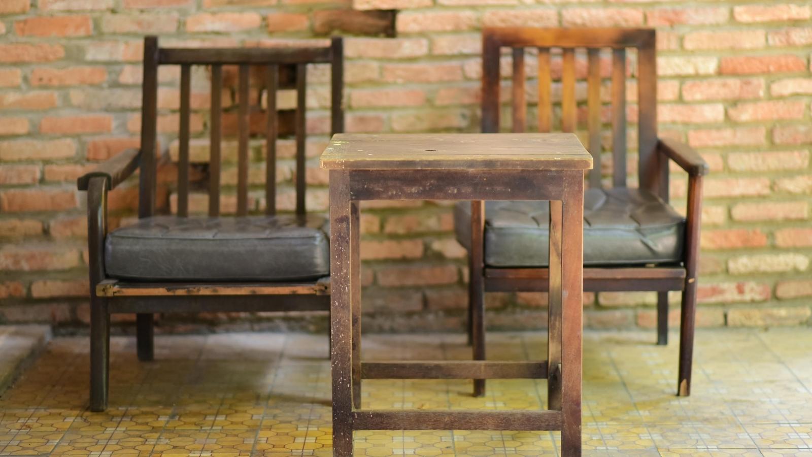 Two old armchairs and an end table in a living room