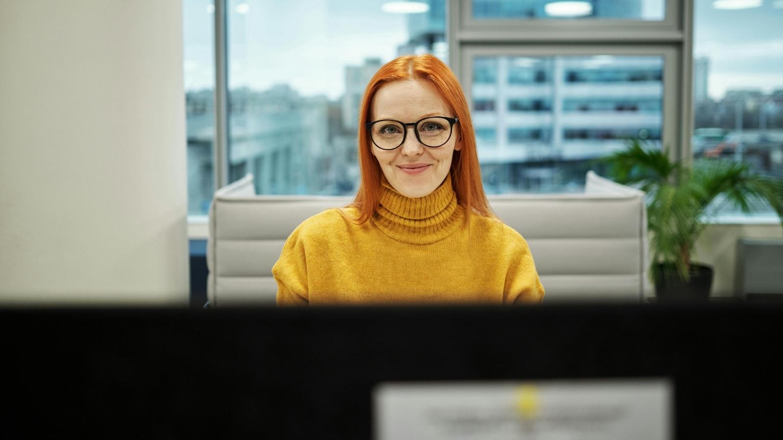 Front Desk Employee Handles Two Businesses Without Extra Pay, Then Posts Sign That Sparks Management Backlash Red-headed woman working at a front desk