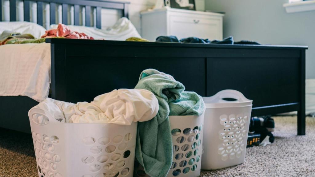 Baskets of dirty laundry sitting in a bedroom