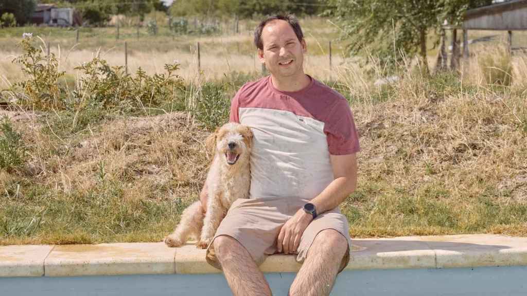 Man sitting and posing with his friend's dog