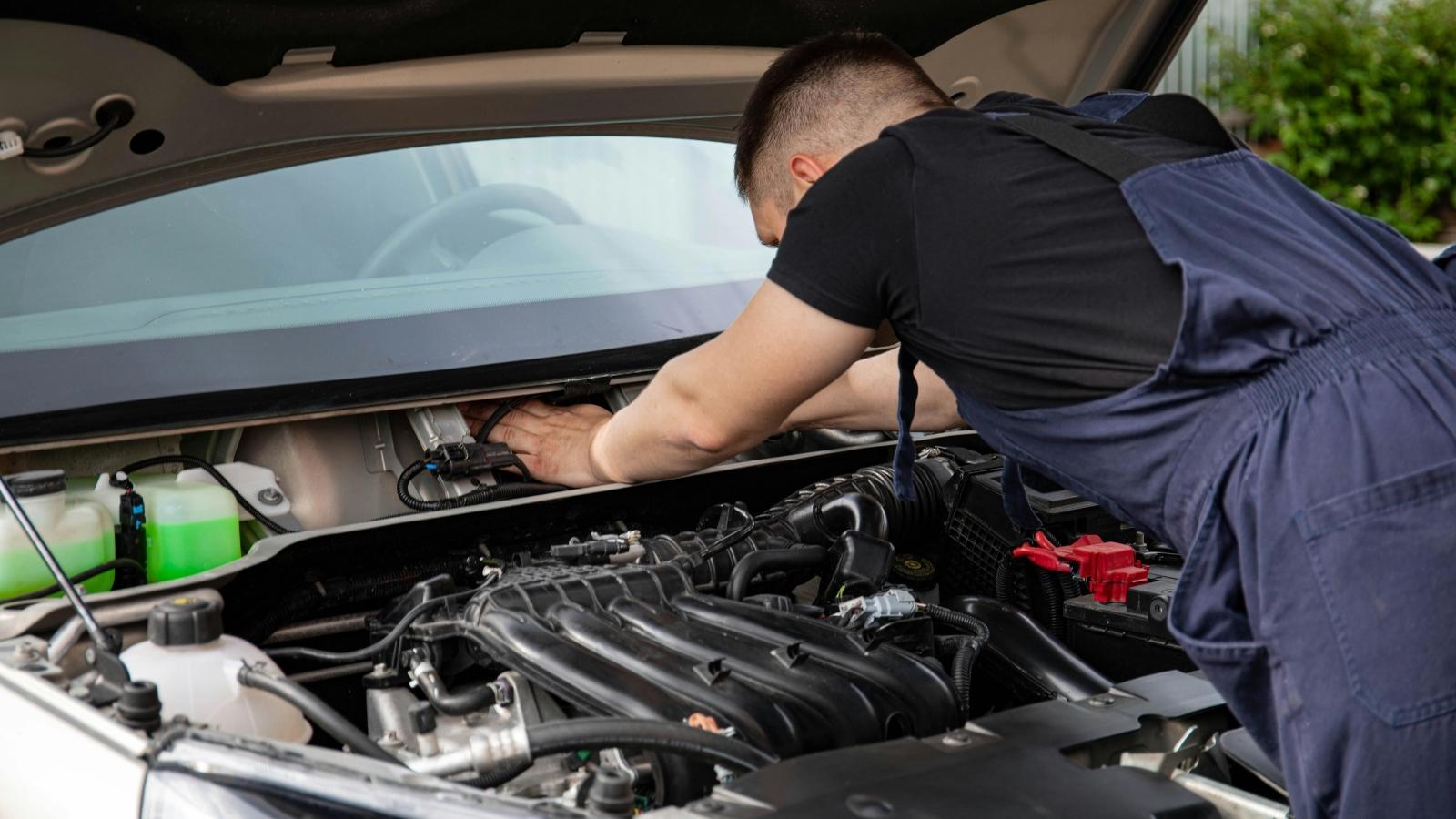 Uncles Car Broke Down While His Nephew Was Borrowing It — Now They Cant Agree on Who Pays the €300 Repair Bill Man working under the hood of an older vehicle