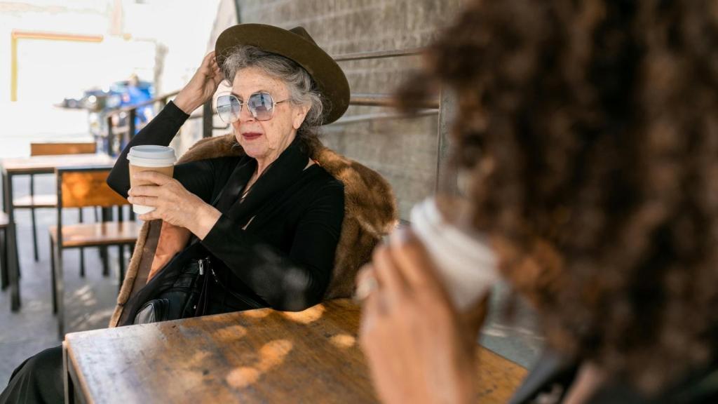 Older woman sitting at a cafe, enjoying a cup of coffee
