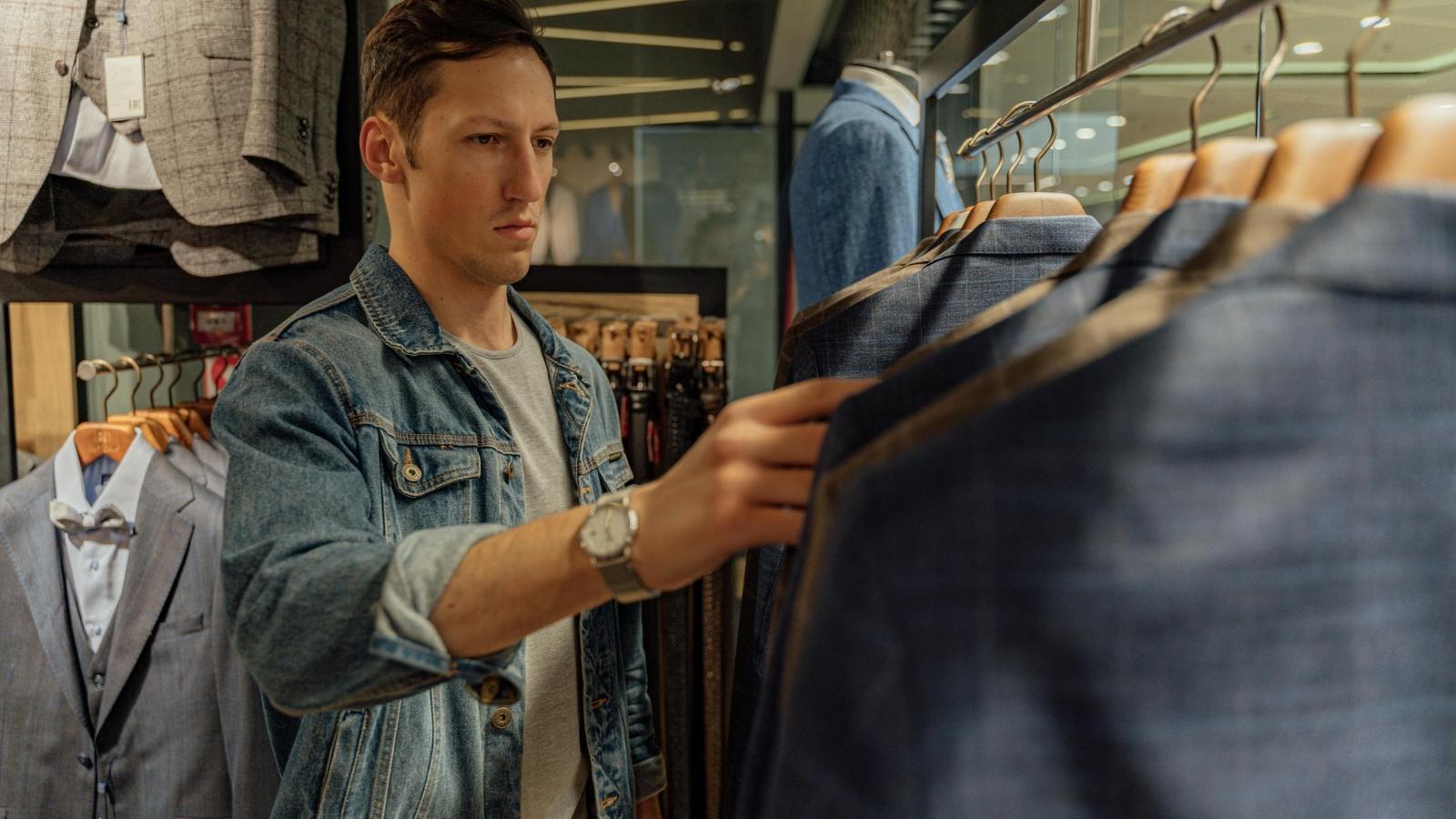 Angry man looking through clothes after doing a return