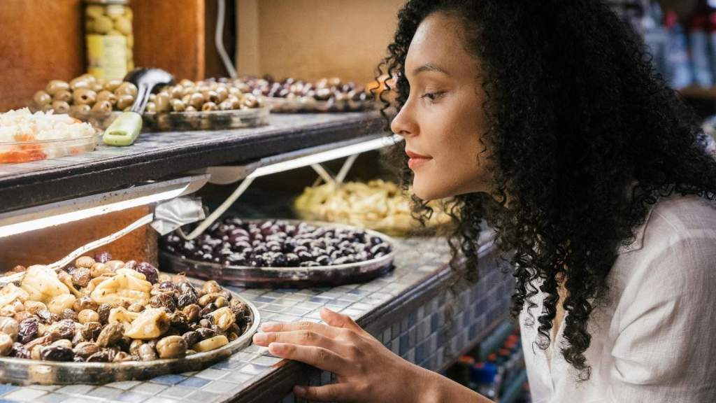 Woman looking at food on a buffet to see if it contains nuts