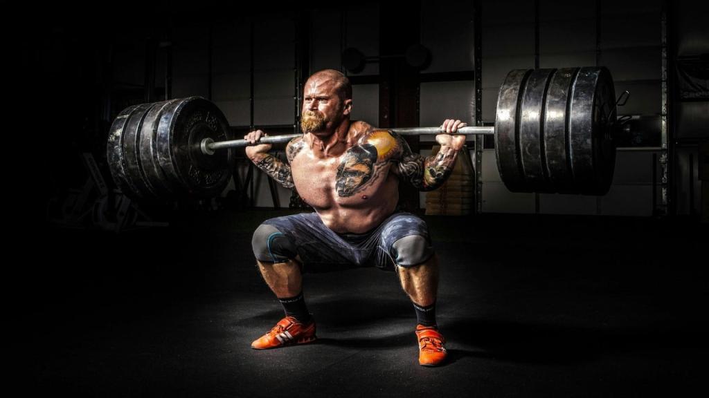 Man using free weights on a barbell to do heavy squats