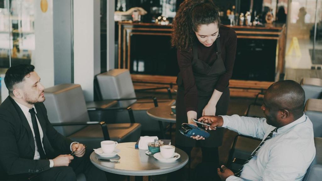 Woman dressed in dark clothes waiting on a table at work