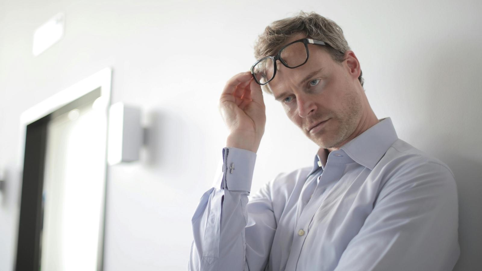 annoyed professional man raising up his glasses