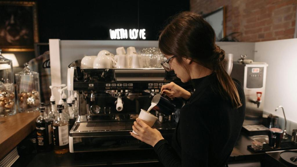 Barista working and making drinks in a coffee shop