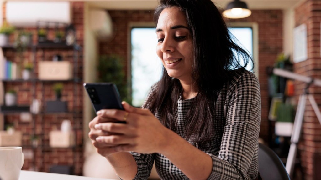 Woman using her phone and smiling