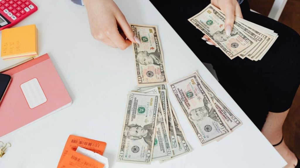 woman counting cash at a desk
