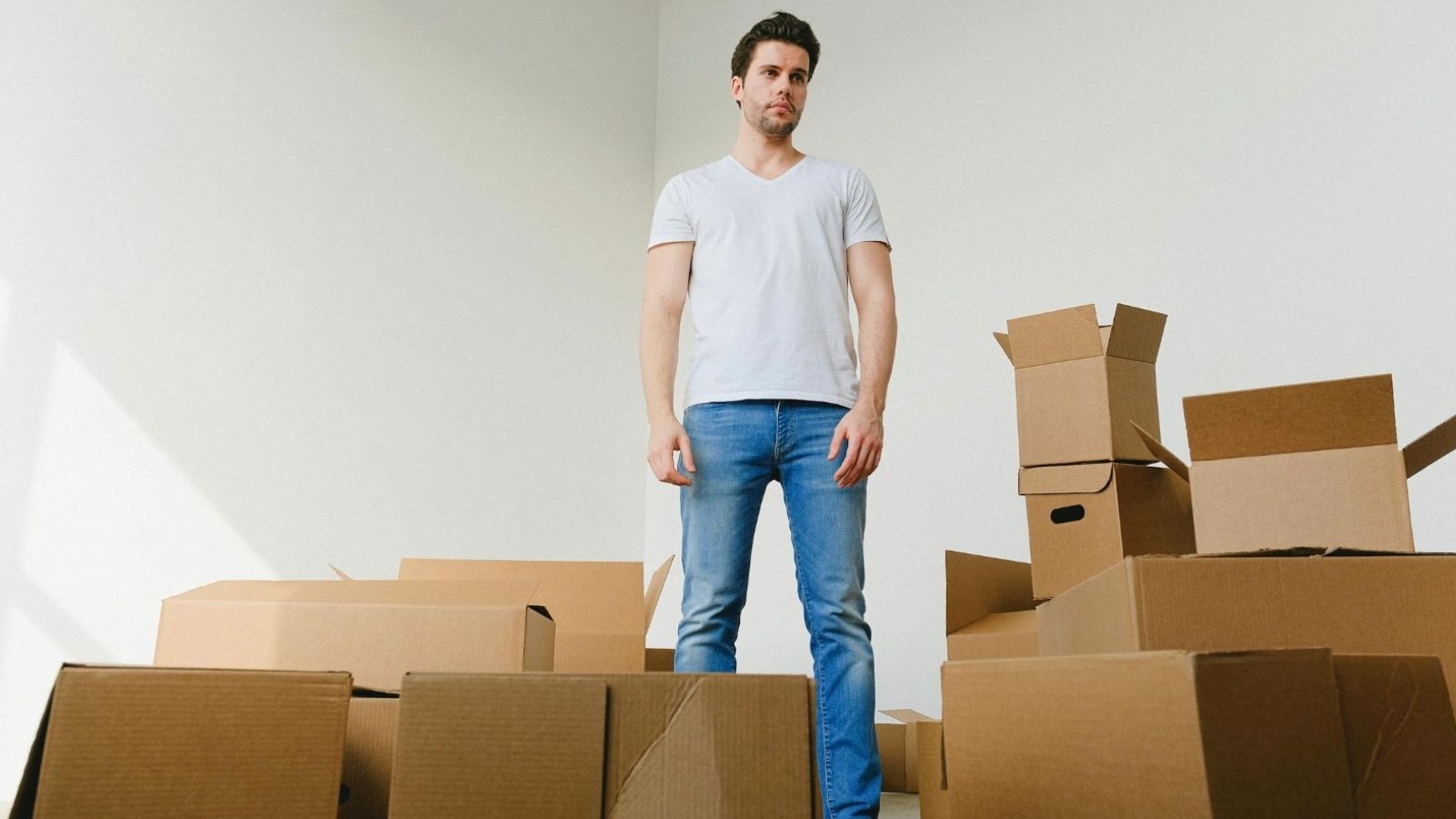 man surrounded by moving boxes
