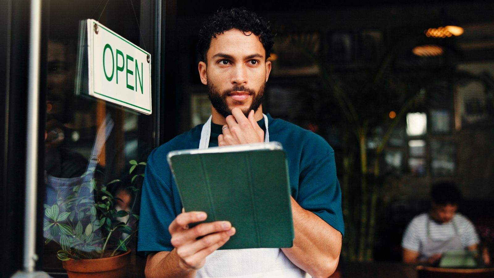 male server standing in restaurant doorway looking worried