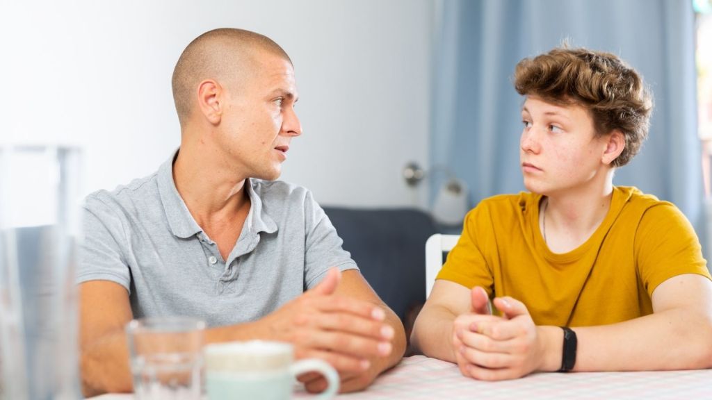 father talking to teenage boy
