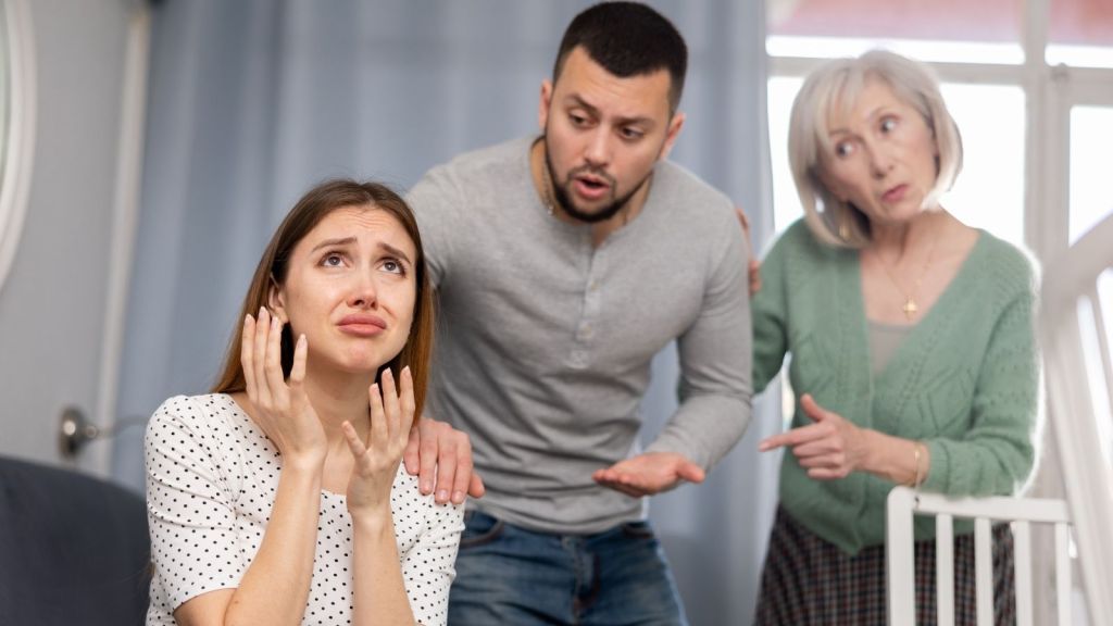 woman really upset while her boyfriend and his mom talk to her