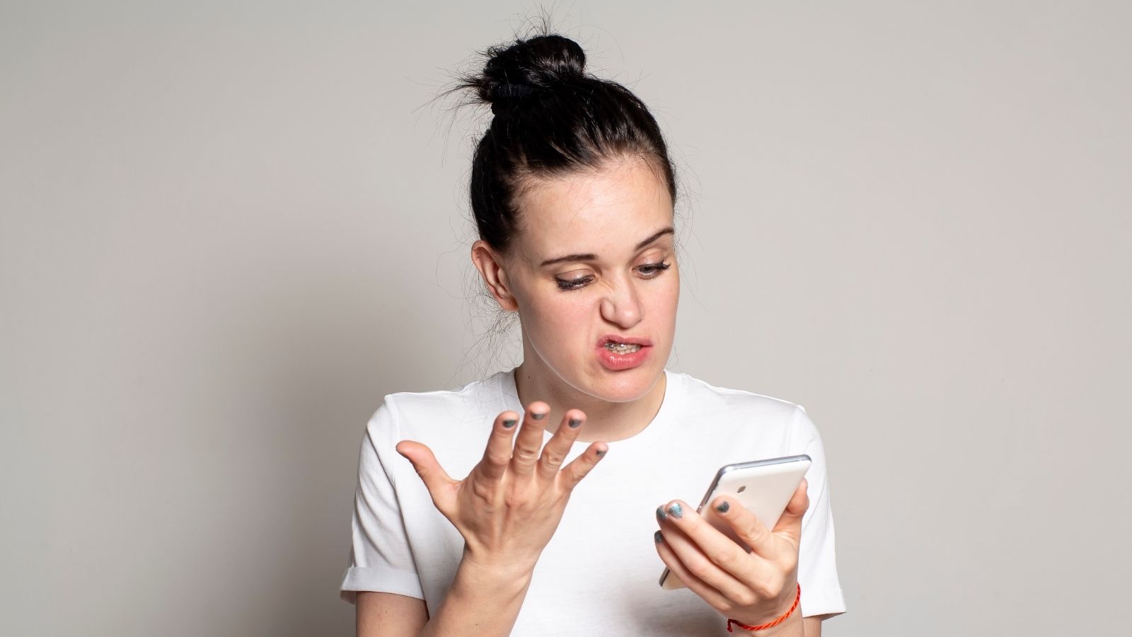 confused woman looking at her phone