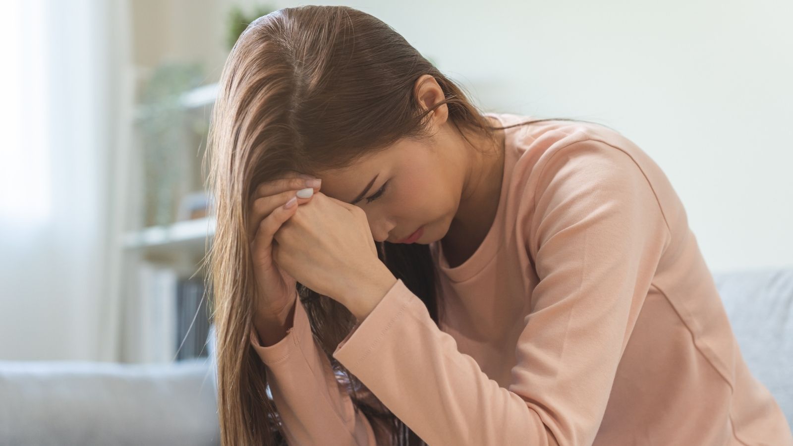 stressed out woman resting her head on her hands