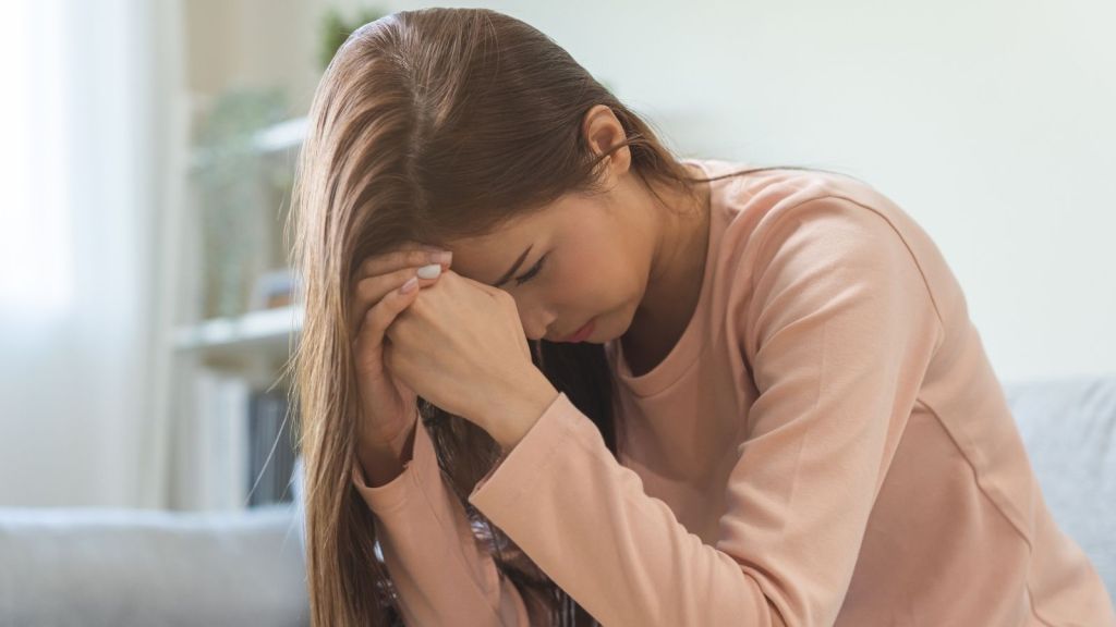 stressed out woman resting her head on her hands