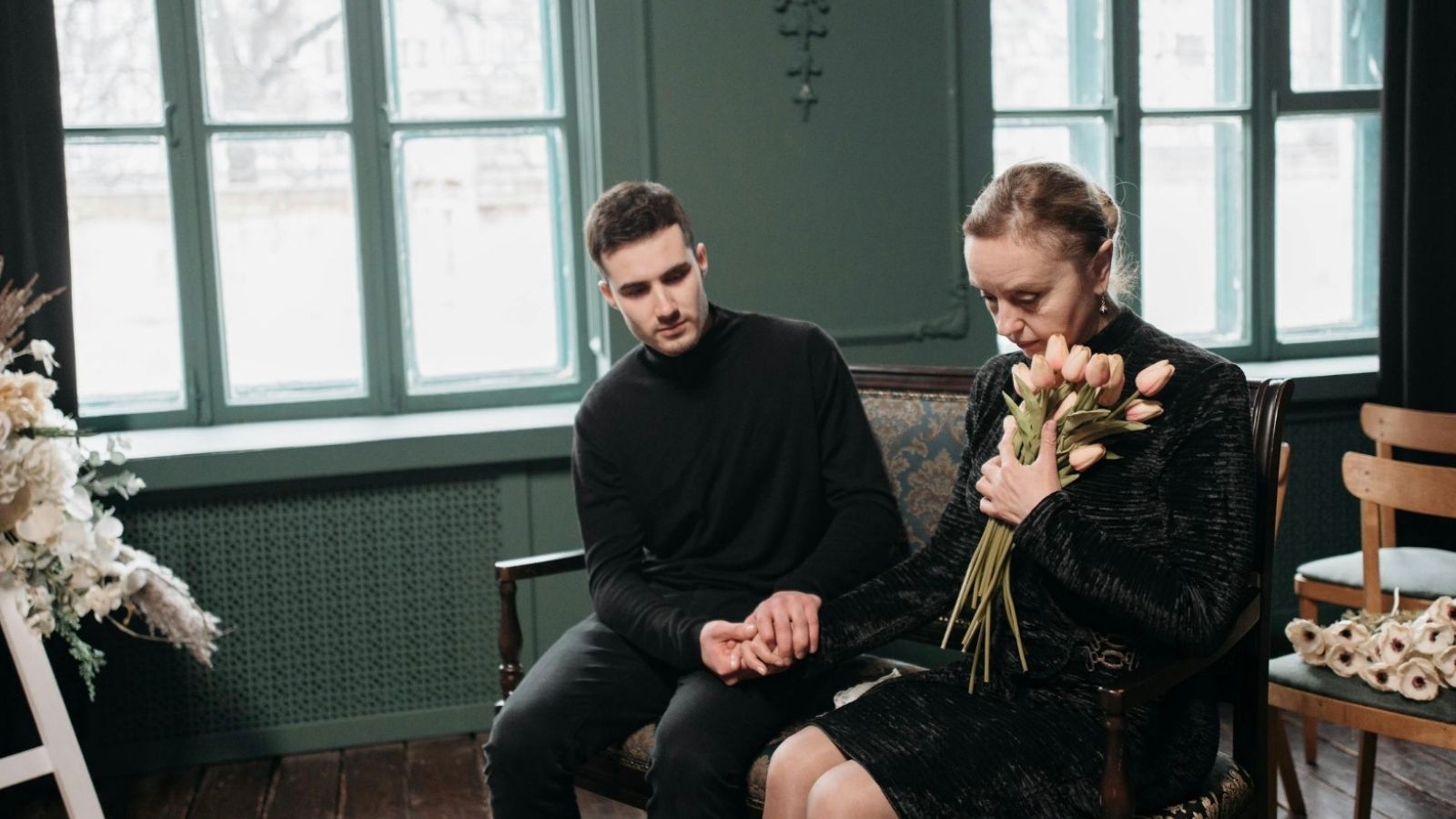 grieving mother and adult son wearing black