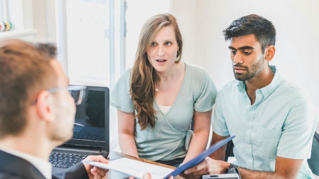 couple looking at lease with landlord