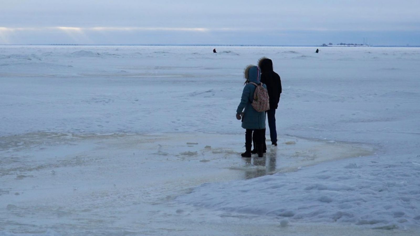 two kids standing on ice in the winter