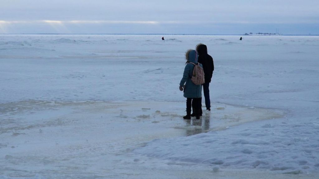 two kids standing on ice in the winter