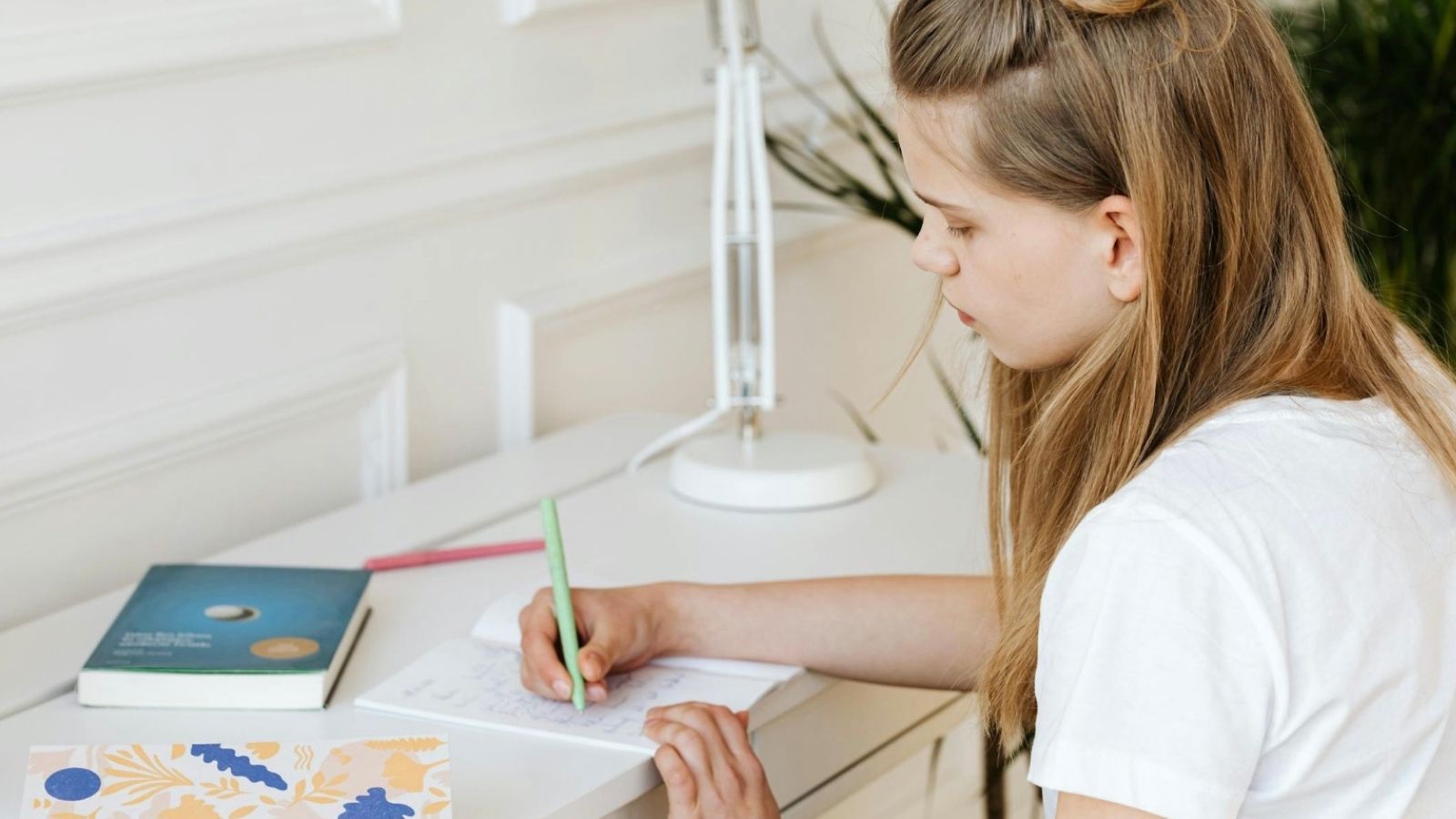 teenage girl writing in a notebook