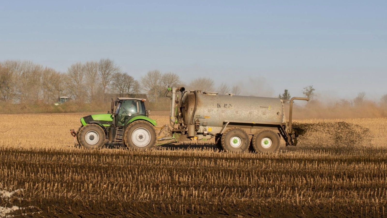 How a Suburban Newcomers War on Farm Smells Made Her a Neighborhood Outcast farmer spreading fertilizer in field with a tractor