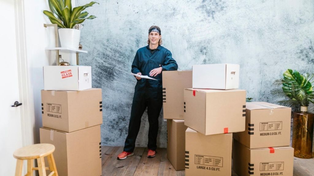 young man surrounded by moving boxes