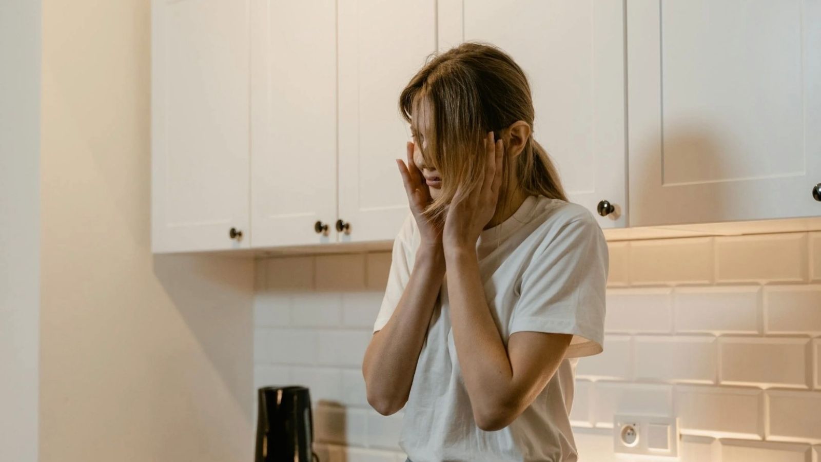 Woman Demands Answers About Weird Tapping Noise Upstairs, and the Neighbors Secret Explodes woman looking distressed touching her ears