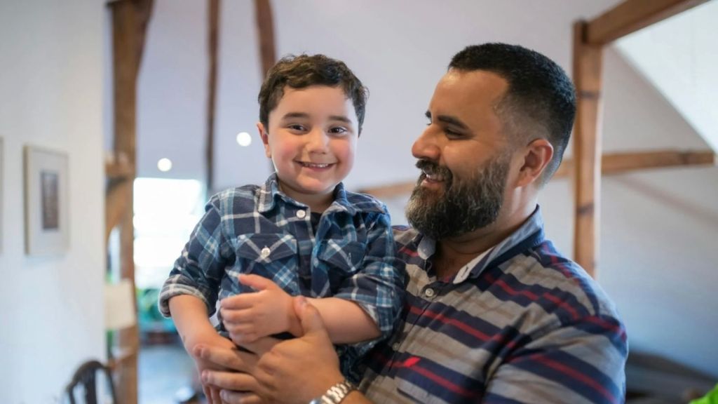 smiling man holding his little boy