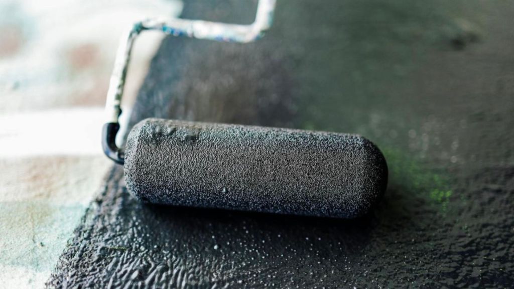 using paint roller to paint with black paint