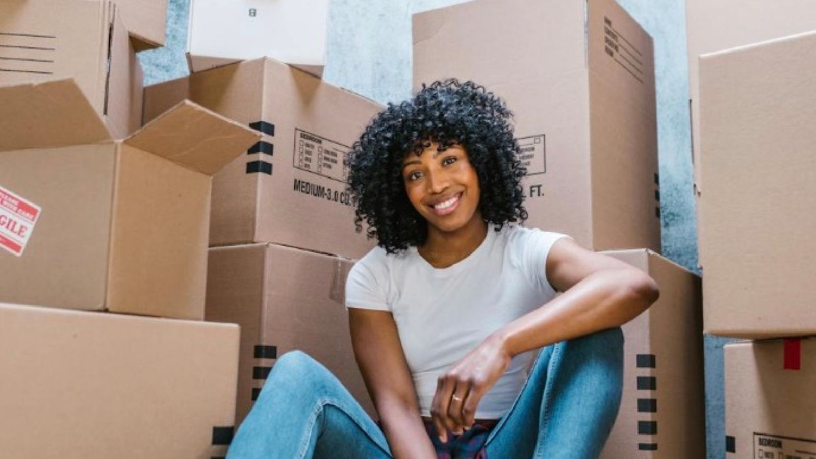 smiling woman surrounded by moving boxes
