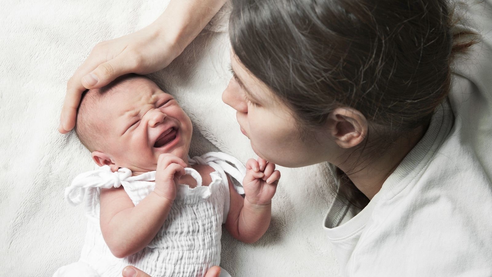 woman trying to calm down a newborn baby