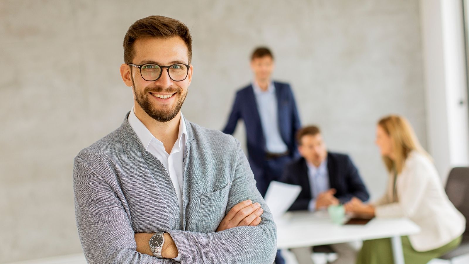 smiling businessman with other employees in the background