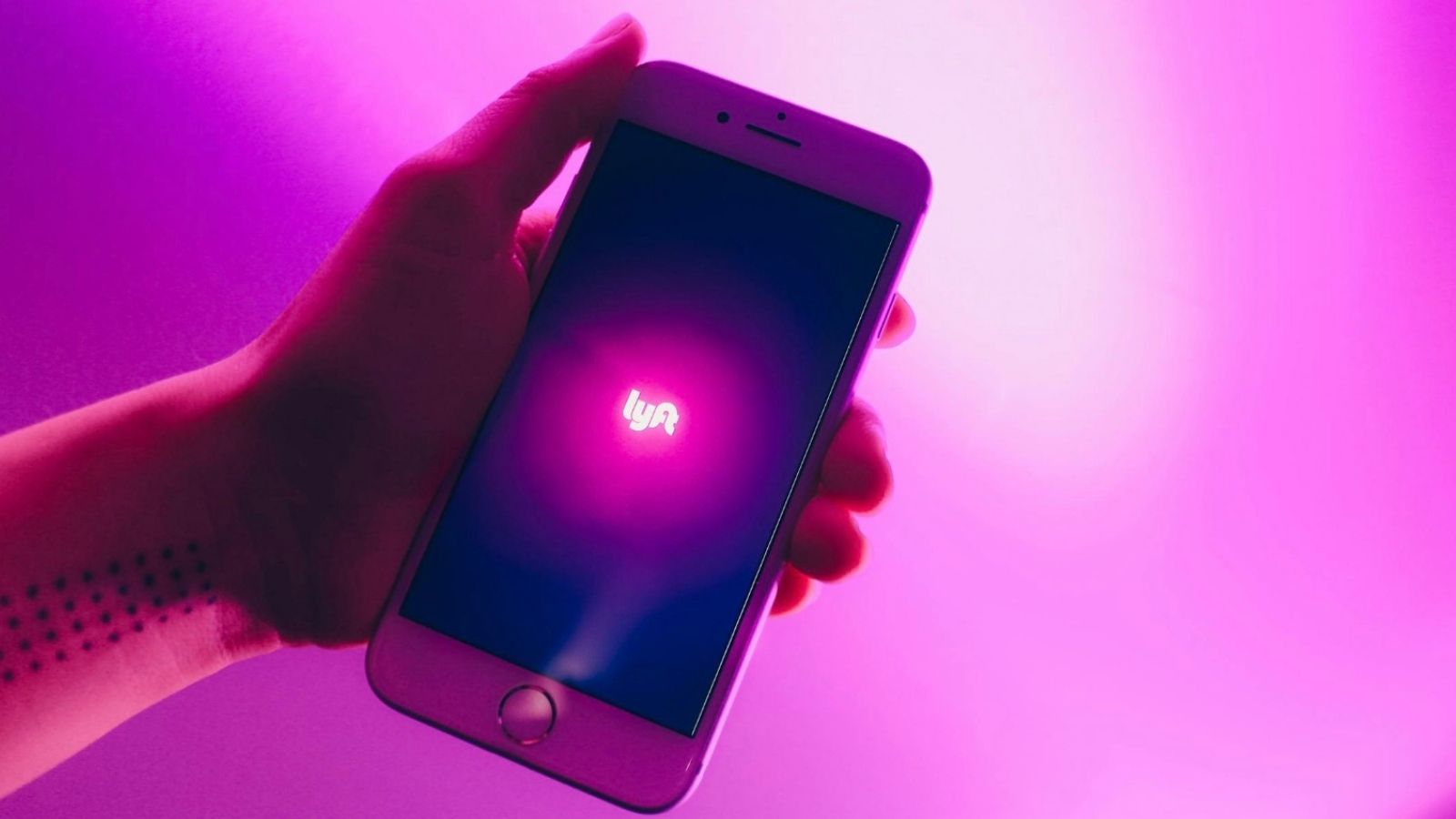 person holding a phone with the lyft logo on the screen