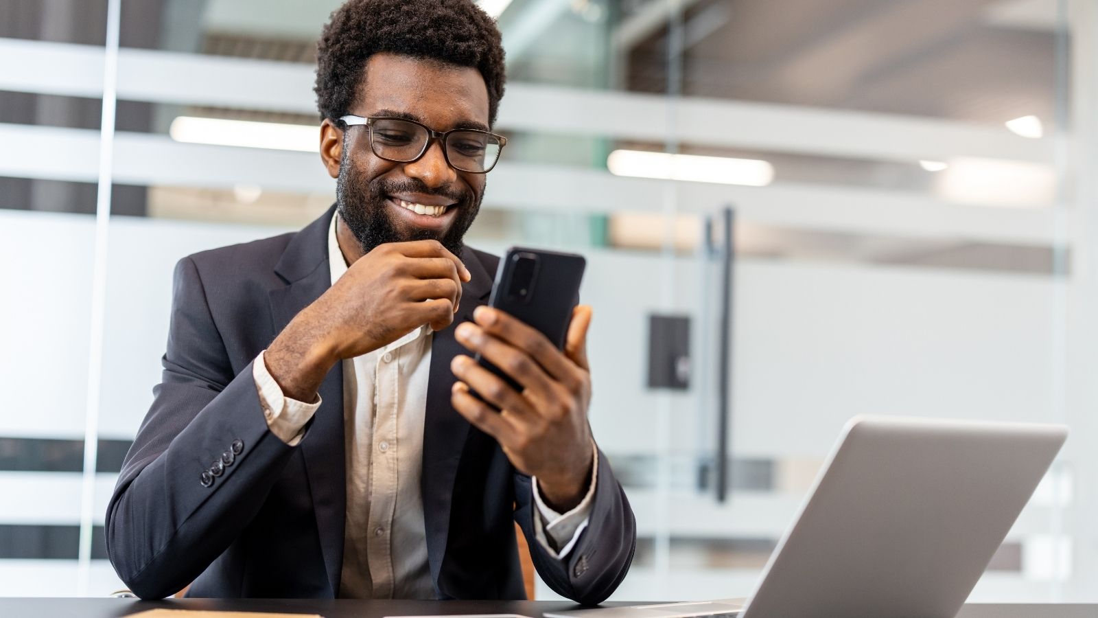 Employee Calls Out Manager for Goofing Off at Work, but Friends Say Texting Supervisor Was a Mistake smiling businessman looking at his phone