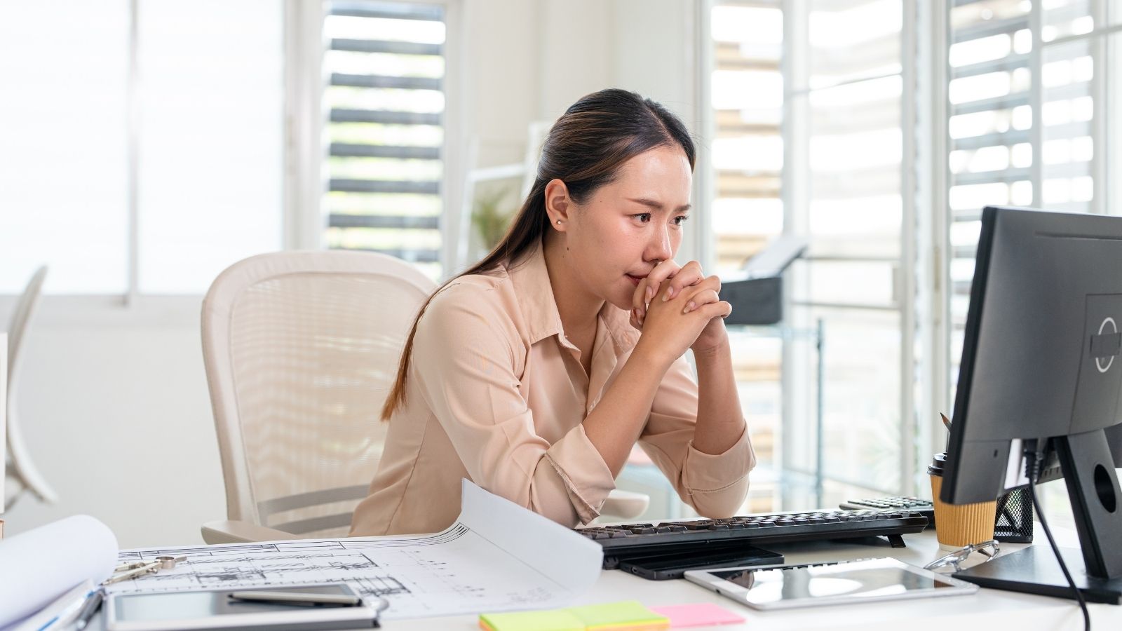“The Money Isnt Worth It:”—Why an Employee Regrets Accepting Her Dream Promotion and Is Ready to Walk Away woman looking at her computer with a serious expression