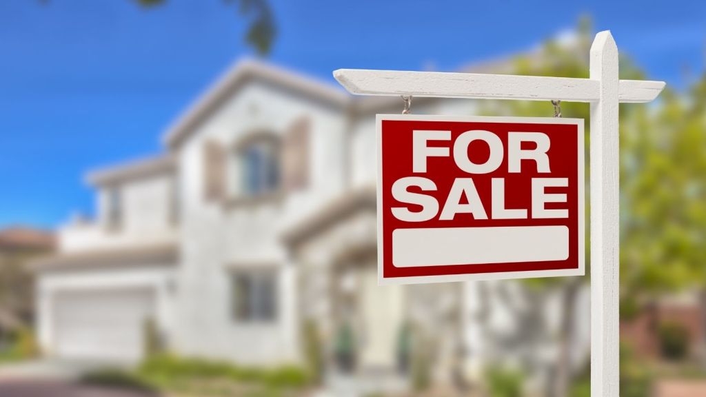 for sale sign in front of a house