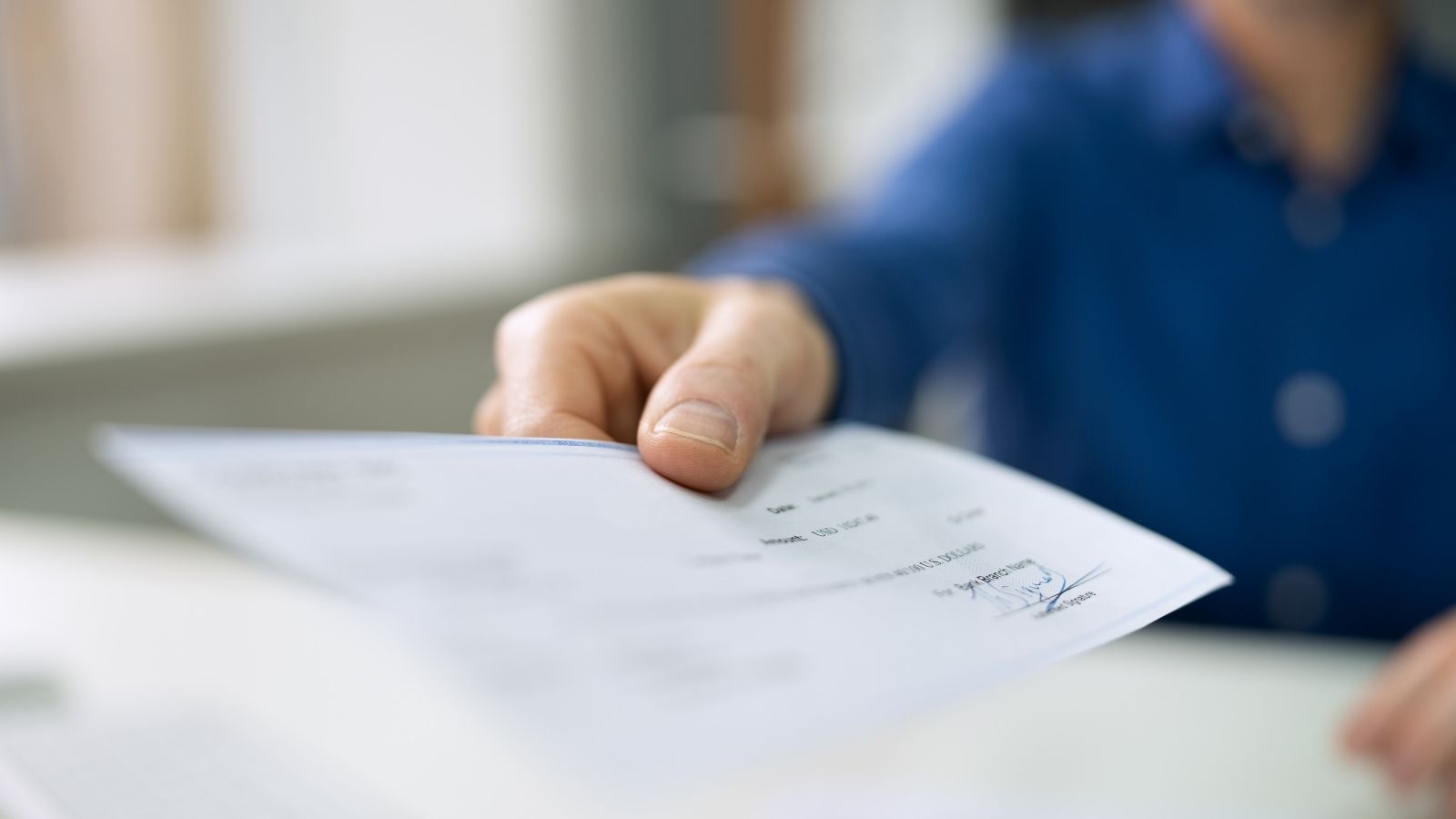 handing employee payroll check