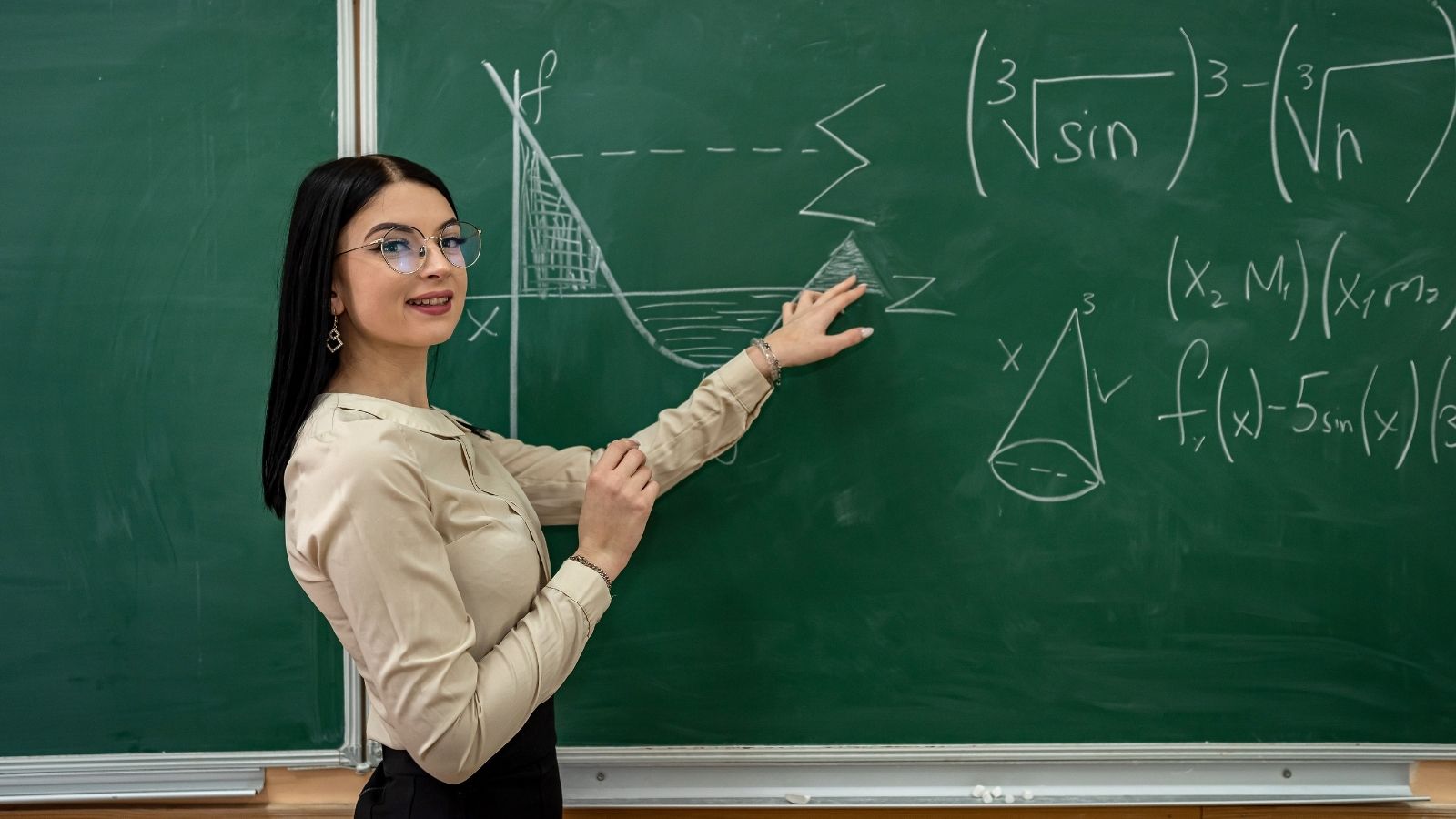 Teacher Introduces Boyfriend to Her High School Principal—Then Panics After Realizing They Share a Hidden Past young female teacher standing at the chalkboard
