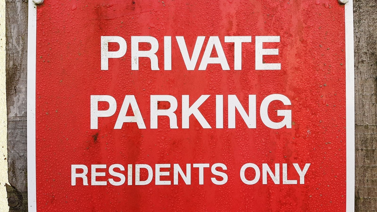 Snobbish Neighbor Mocks New Family as Just Renters—Then Faces Supreme Karma When They Buy the Condo and Become HOA President red sign that reads "private parking residents only"
