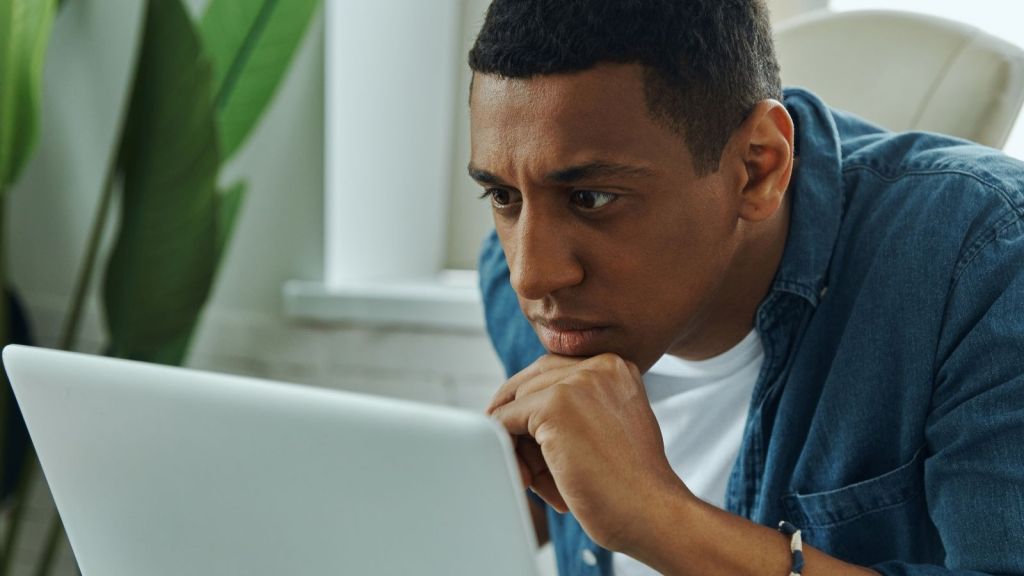 black man looking at his computer