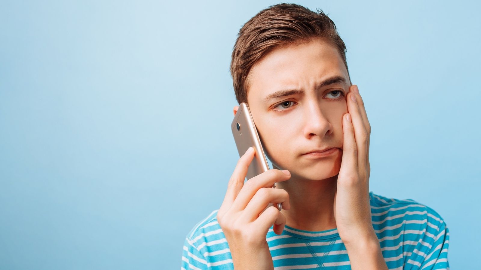 frustrated teenage boy talking on the phone