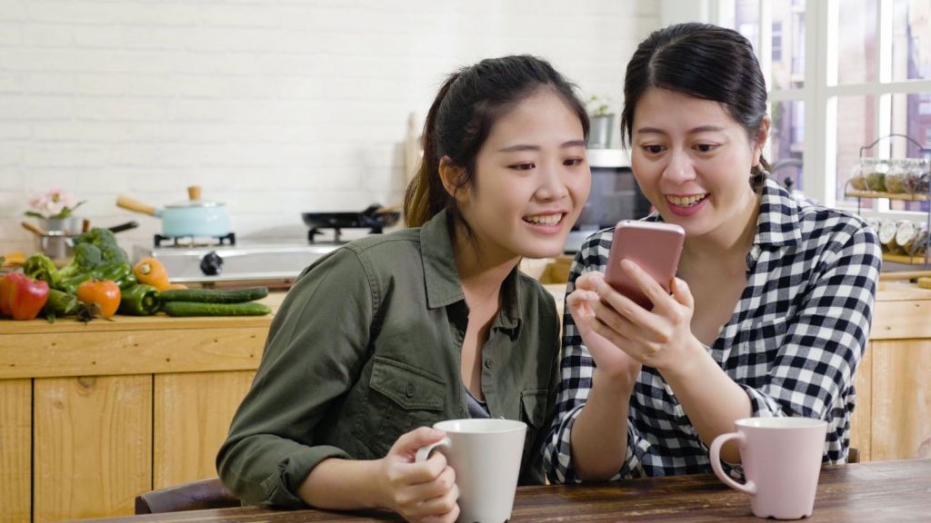 two female roommates looking at a phone