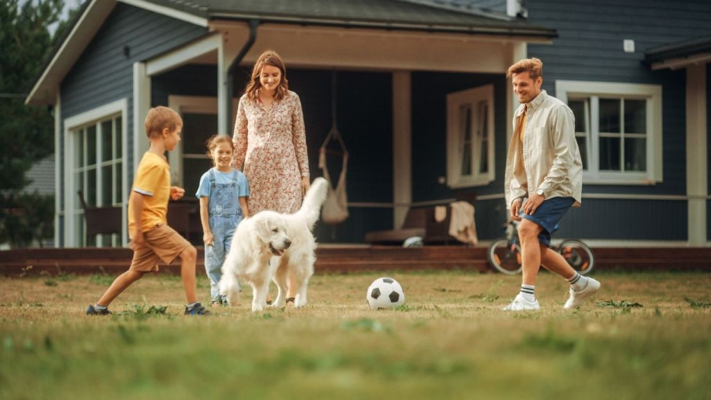 family playing soccer in the front yard