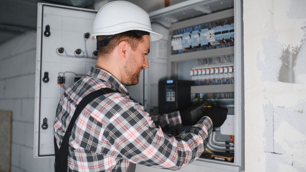 electrician looking at the breaker box