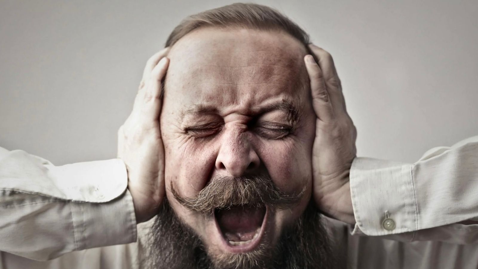 He Tracked a Stream of Suspicious Strangers Entering His Neighbor’s House—and Triggered a Major Police Raid man screaming and covering his ears while closing his eyes