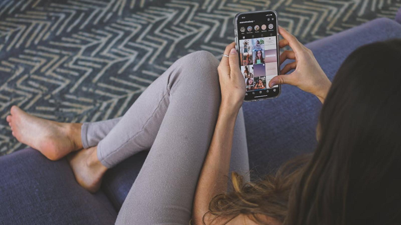 Woman browsing Instagram on her phone while sitting