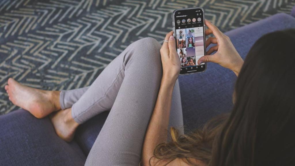 Woman browsing Instagram on her phone while sitting