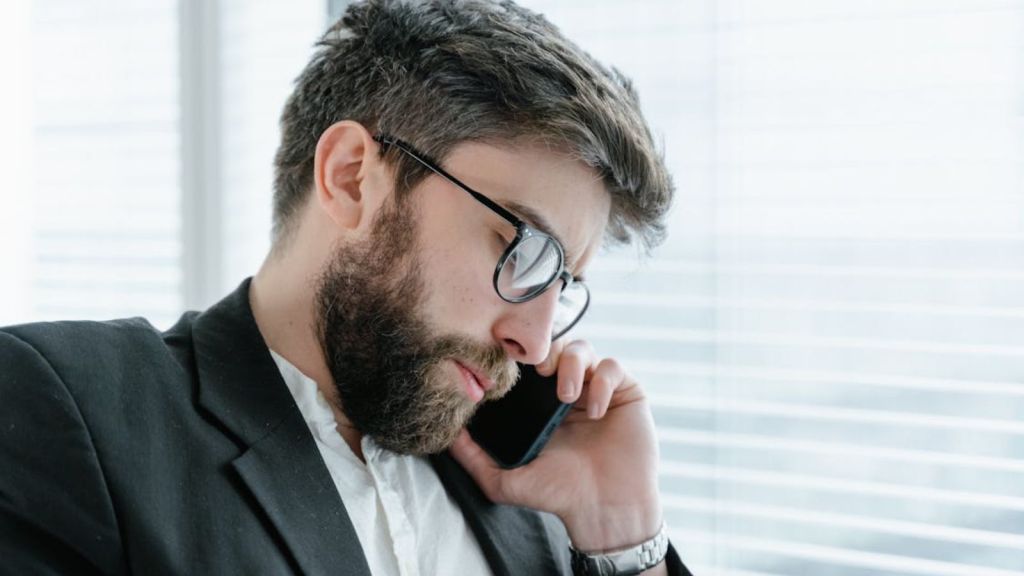 Employee holding up his phone by his ear